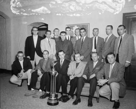 Group portrait of the University of Idaho's IFC with a trophy.
