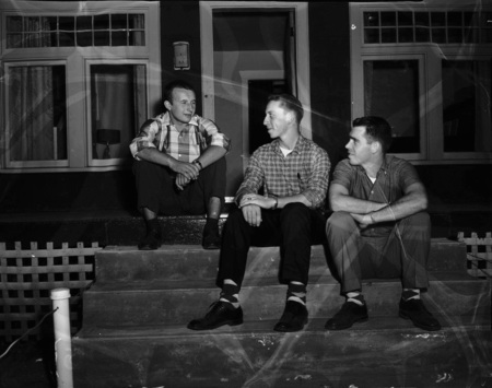 Hungarian refugee Mike Horvath (left) talking with students on a house porch.