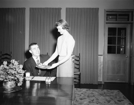 Home Economics student serving potatoes to student.