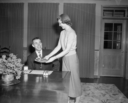 Home Economics student serving potatoes to student.