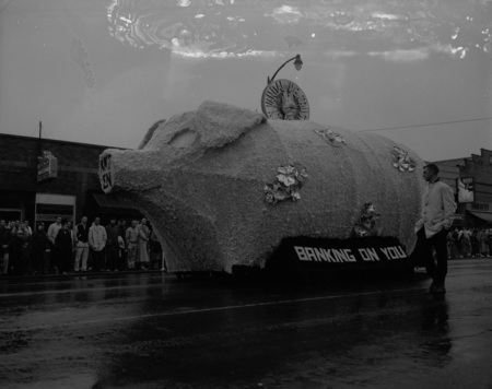 A homecoming float depicting a piggy bank reading "banking on you" in downtown Moscow.