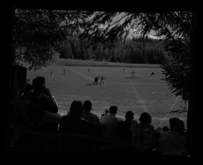 A photograph from behind a small crowd at a baseball game.