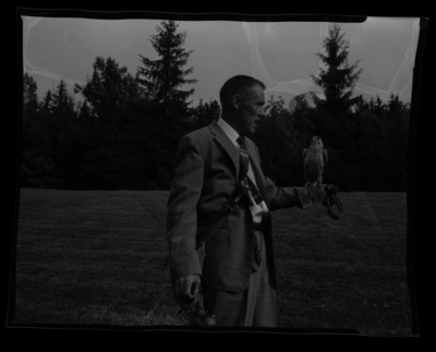Morlan Nelson, conservationist and falconer, holding a falcon in MacLean Field to educate 4-H members at the College of Agriculture.