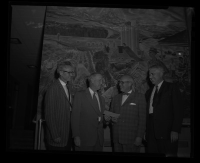 A group photo of the College of Agriculture recieving the Sears Foundation check. The Kirkwood Mural is seen behind them.