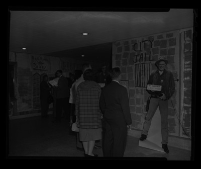Members of the Idaho Cattlemen's Association view the decorated lobby of the SUB. A life sized cut out of the ICA President Slats Wilson in a sherrif's outfit greets them with a sign that reads "Hi pardoner!".