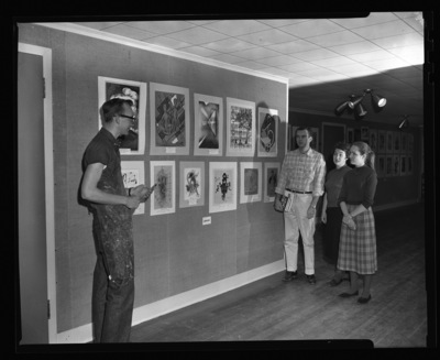 University of Idaho Art student Iain Baxter showing artwork from Lewiston High School students to several classmates.