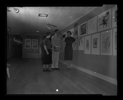 Mary Kirkwood, painter and University of Idaho Professor, showing high school student's art work to University students.
