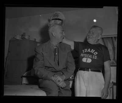 Sports Publicist Ken Hunter (left) and athletic trainer Packey Boyle (right) preparing for the 1960 Winter Olympic Games with a fur hat at the University of Idaho.