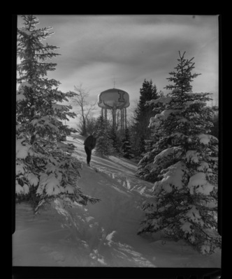 Student Iain Baxter skiing on University of Idaho campus, the University water tower can be seen in the background.