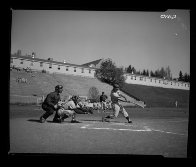 A photograph of a batter swinging in a baseball game, catcher and umpire can be seen behind him.