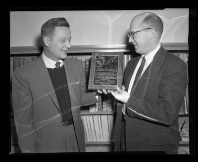 Student Robert Kessell (left) and Dean Kendrick (right) with plaque won for outstanding research awarded by delta pi epsilon.