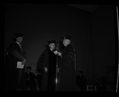 Carl G. Paulsen (center) is hooded and receives an honorary Doctorate of Science degree on stage with Dean of Engineering, Alan Janssen (left), and President Theophilus (right) at commencment.
