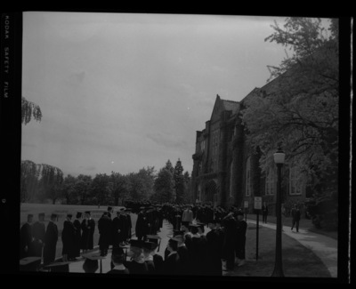 Students stand outside of the Administration Building for the traditional Commencement Parade.