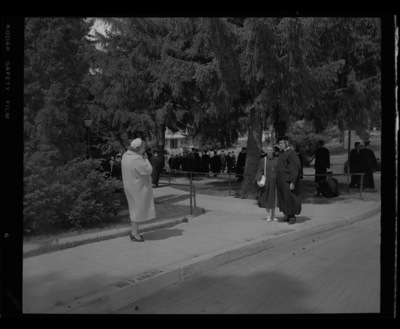 Graduate poses outside with woman for commencement photos outside the Old Gymnasium and Armory..