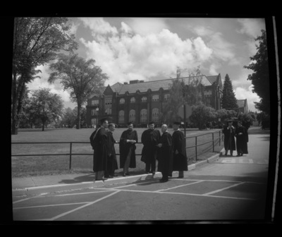Students stand outside of the Administration Building for commencement.