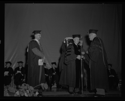 Carl G. Paulsen (center) is hooded and receives an honorary Doctorate of Science degree on stage with Dean of Engineering, Alan Janssen (left), and President Theophilus (right) at commencment.