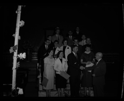 President Theophilus congratulates outstanding seniors at the annual May Fete event in Memorial Gym. Top row (l-r): Neal Newhouse, Dick Loeppky; Clyde Lofdahl, Robert Prestel; Lon Davis, Delbert Fitzsimmons; James Golden, Mary Van Orman, Suzanne Roffler, Charels Brockway, Tommy Stroschien; bottom: Diana Kay Conrad, Carolyn Edwards, Dick Kerbs, and Marge Erstad.