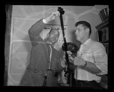 Mr. Paul Kaus shows a reel of film to one of his Audio-Visual Aids class students.