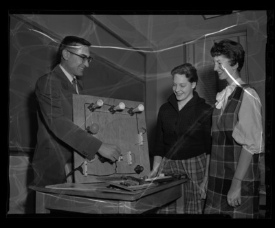 Project Director Bill Works explaining home wiring to two home economics students.
