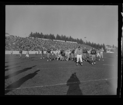 Football players on the field during the Homecoming game.