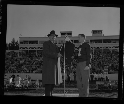 Wanek Stein (left) is named "Vandal Booster of the Year" and presented with an "I" blanket by Robert Hansen, president of the "I" Club during halftime at the 1959 homecoming game.