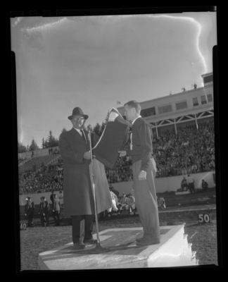 Wanek Stein (left) is named "Vandal Booster of the Year" and presented with an "I" blanket by Robert Hansen, president of the "I" Club during halftime at the 1959 homecoming game.
