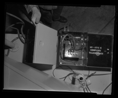 Radio Center advisor Leon Lind shows the inside of a coupling transformer.