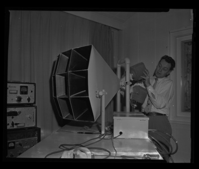 Radio Center advisor Leon Lind adjusts a loud speaker.