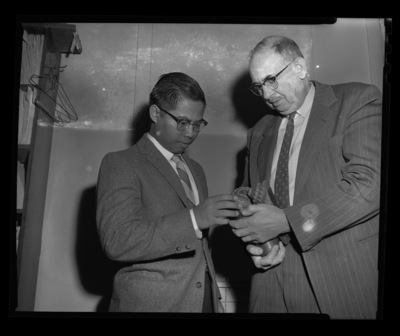 College of Mines professor W.W. Staley with visiting scholar from Burma inspecting a tricone mining drill bit.