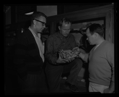 College of Mines students examining a geode rock sample with large crystals.