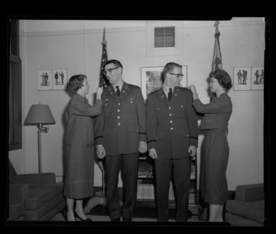Army ROTC  officers Robert L. Prestel (left) and Charles Brockway (right) get their lapels pinned as part of their promotion at Uniersity of Idaho.