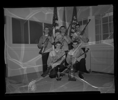 Championship Navy rifle team posing with their rifles and trophies. Kneeling, left to right: Charles F. Bigsby, Roderick L. Mayer. Standing, left to right: Ronald R. Thomas, Ray C. Shubert, Harold T. Barraclough.