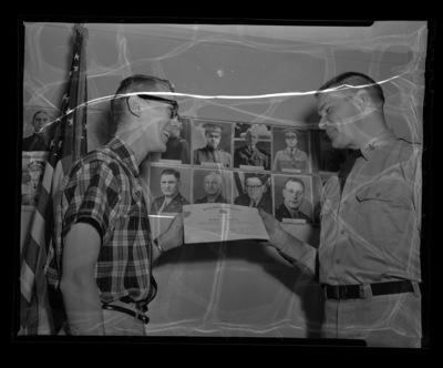 Captain Nabell giving certificate of appreciation from the Reserve Officer's Training Corps to Robert Whipple.