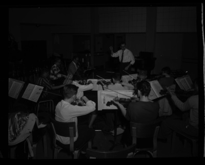Members of the symphony orchestra practice together. Professor LeRoy Bauer conducts.