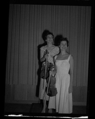 School of Music students Georgia Finch and Sally Maddocks posing with their violins.