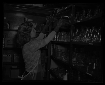 Bonnie Barney puts away a large beaker in the plant pathology laboratory.