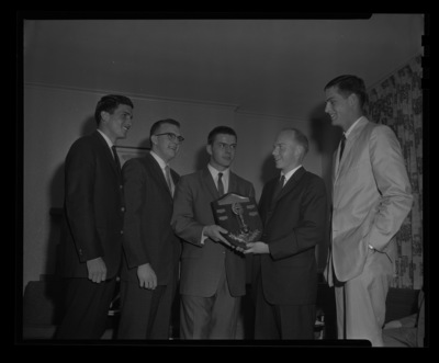 Students with Sigma Chi plaque