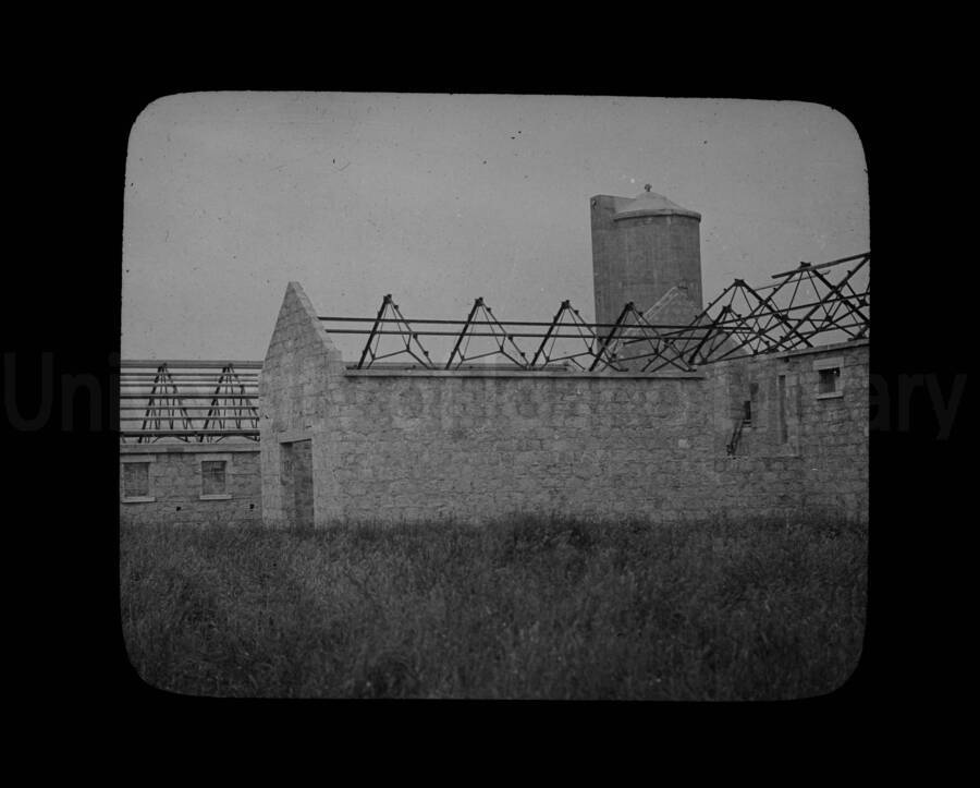A farm building either under construction or after having the roof removed.