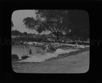 Men working in a body of water, either for construction purposes or harvesting materials.