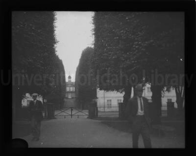 Facade of a building in the distance in an unknown location. Two men are seen in the foreground.