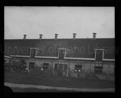 Cattle graze outside of a barn on an unidentified property.