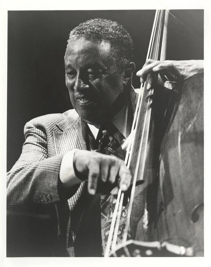 Ray Brown playing the bass, facing left.  10 x 8 inch black and white photograph.