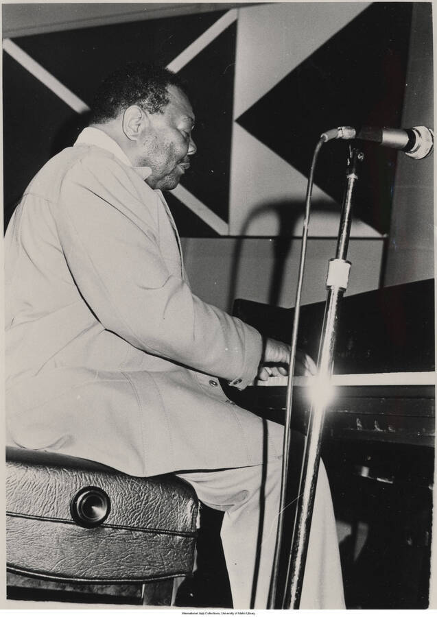 7x 5 inch photograph; Jay McShann playing the piano. Typewritten on the back of the photograph:  Jay McShann at 1979 jazz party