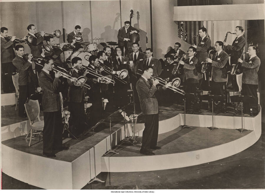 7 1/2 x 10 inch photograph; a band. Label on the back of the photograph reads: The Glenn Miller band, 1941; Ray Anthony and Billy May in trumpet section; Tex Beneke and Hal McIntyre in sax section (all later led bands of their own)