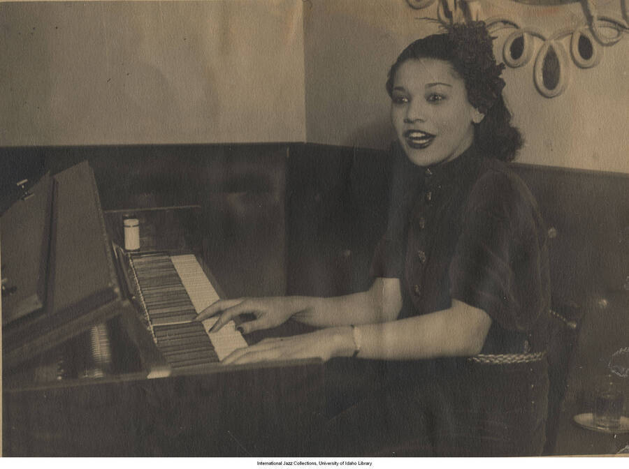 7 x 9 1/4 inch photograph; Una Mae Carlisle playing the piano