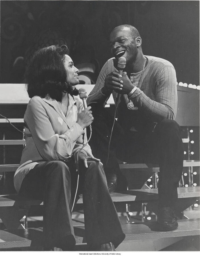 10 x 8 inch photograph; Brock Peters with an unidentified woman holding microphones
