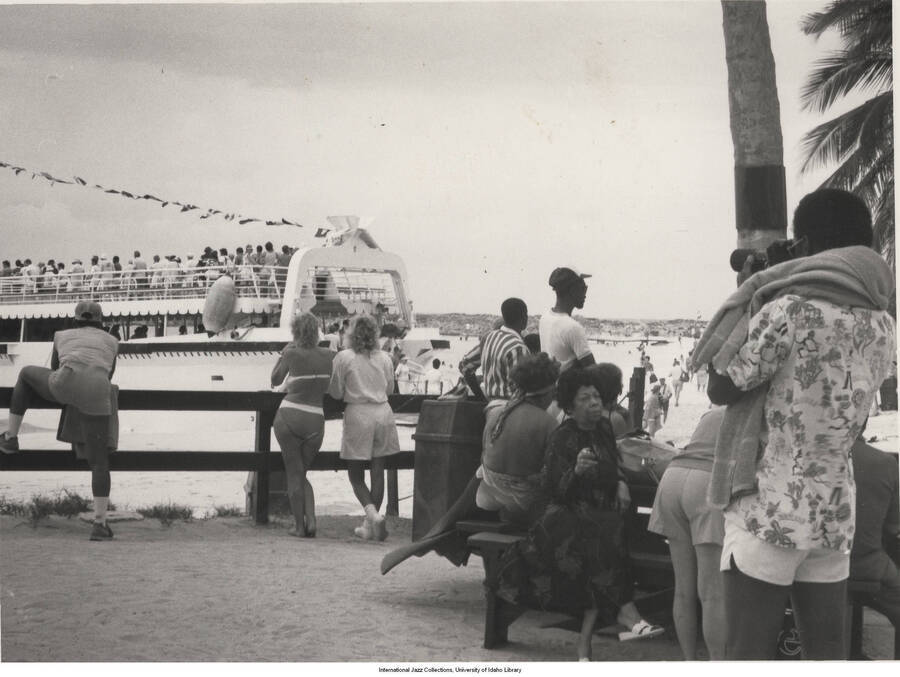 5 x 7 inch photograph; unidentified persons observing a passing boat