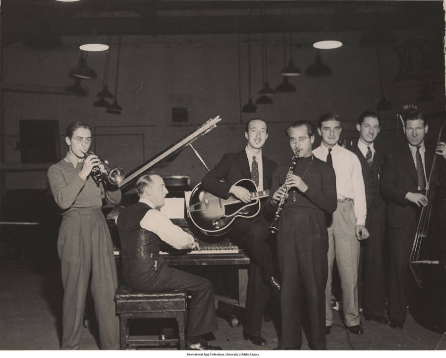 8 x 10 inch photograph; Ye Olde English Swynge Band (Danny Polo on clarinet, Tommy  McQuarteron cornet, Eddie Freeman on guitar, and  Eddie Macauley on bass) and Leonard Feather at the Decca studio