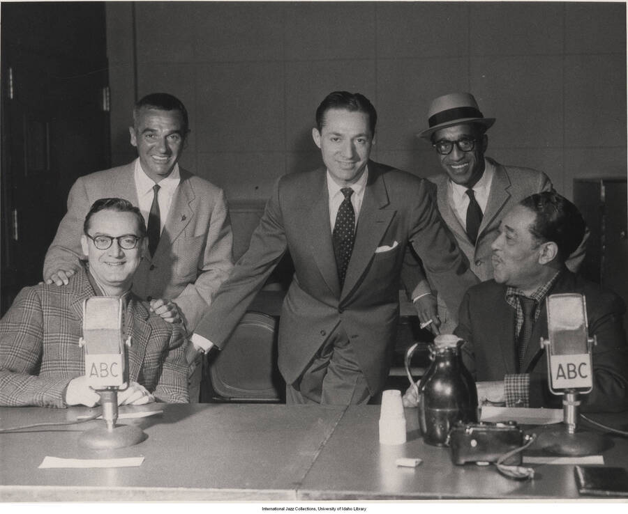 8 x 10 inch photograph; Steve Allen, Gene Krupa, Leonard Feather, Sammy Davis Jr., and Duke Ellington, at the New York radio show, Platterbrains. This photograph is published in Leonard Feather's book The Jazz Years: Earwitness to an era