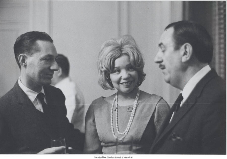 3 1/2 x 5 inch photograph; Leonard Feather with unidentified man and woman, at a cocktail party